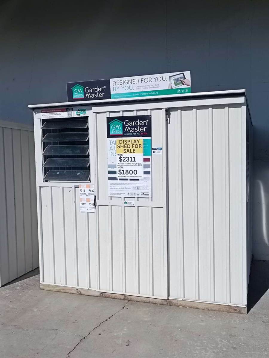 White Garden Master display shed with sales signs and louvered window
