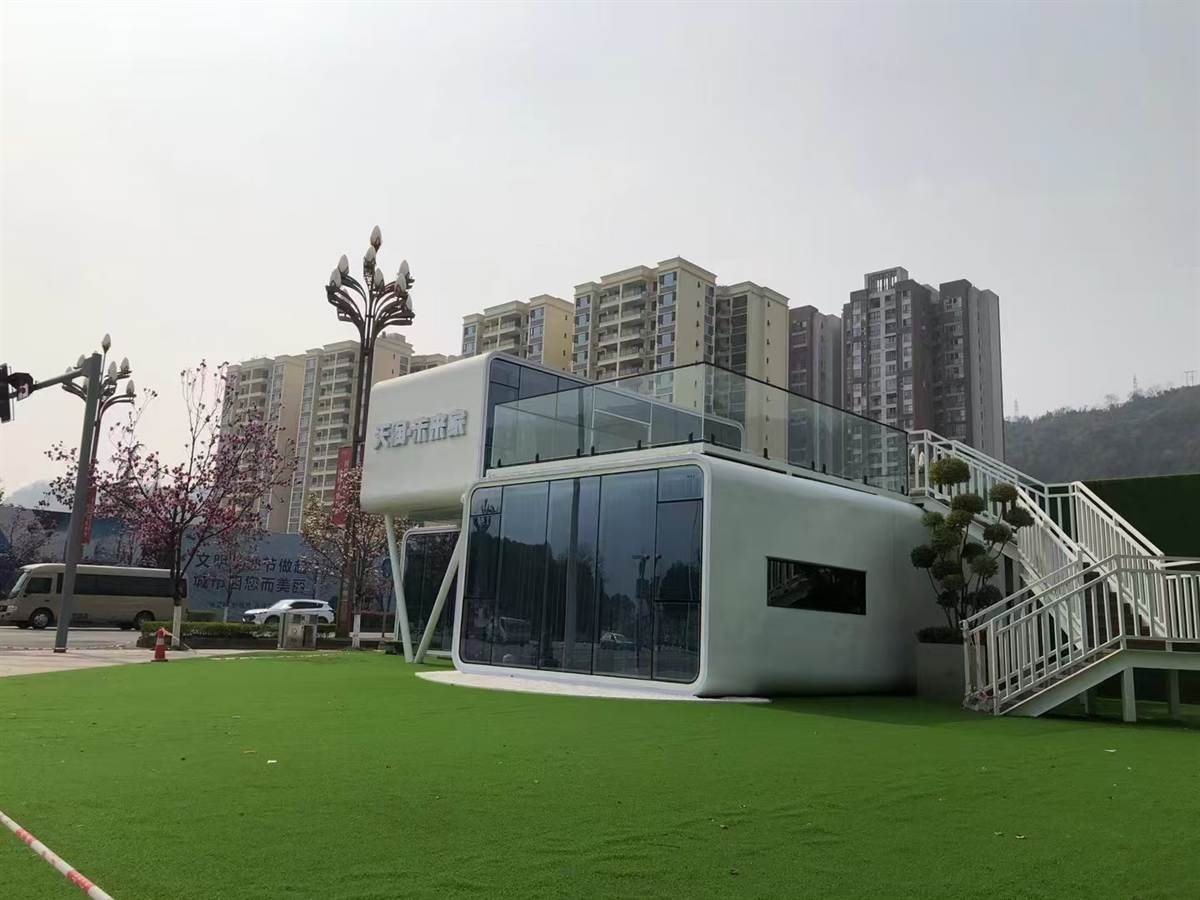 Two-storey commercial modular display unit with rooftop terrace and exterior stairs